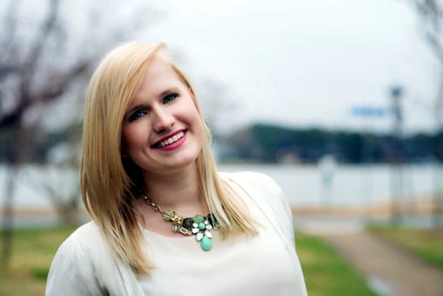 Sarah-Grace Prestidge smiling in a white shirt and green necklace